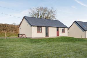 a white house with a picnic table in a yard at Sunny Cottage in Brecon