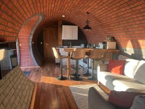 un salon avec un canapé et un mur de briques dans l'établissement Otters View, à Rhayader