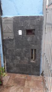 a brick wall next to a building with a heater at CASA PRAIA GRANDE i146 in Praia Grande