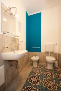 カステッランマーレ・デル・ゴルフォにあるCasa Heliosのバスルーム(シンク、トイレ付)、青いドアが備わります。