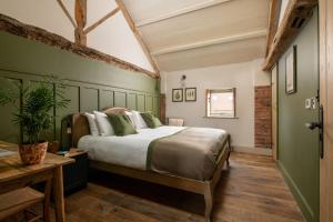 a bedroom with a large bed with green walls at The Grand Barn in York