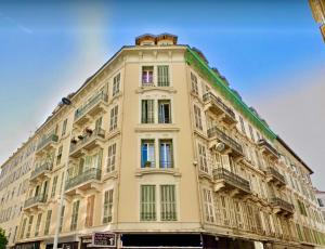 a tall yellow building with windows and balconies at Appartement Urban 5 in Nice