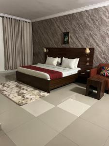 a bedroom with a large bed and a chair at Posh Hotel and Suites Victoria Island in Lagos