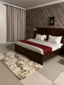 a bedroom with a large bed and a rug at Posh Hotel and Suites Victoria Island in Lagos