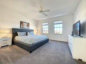 a bedroom with a bed and a flat screen tv at 5 Bed South Facing Pool close to Disney villa in Davenport