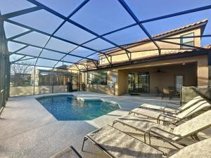 a patio with chairs and a swimming pool at 5 Bed South Facing Pool close to Disney villa in Davenport