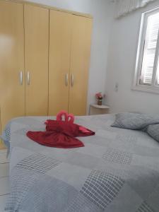 een rode badjas bovenop een bed bij Casa Dos Praieiros in Jaguaruna