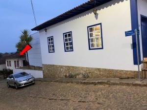 Casa no Centro Histórico de Catas Altas في كاستاس ألتاس: سيارة متوقفة أمام مبنى أبيض