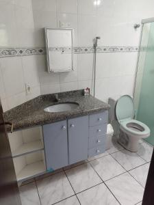 ein Bad mit einem Waschbecken und einem WC in der Unterkunft BONA CASA PERUÍBE in Peruíbe