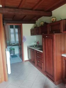 eine Küche mit Holzschränken und einem Waschbecken in der Unterkunft La Girandola in Soriano nel Cimino