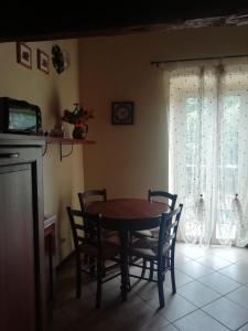 ein Esszimmer mit einem Tisch, Stühlen und einem Fenster in der Unterkunft La Girandola in Soriano nel Cimino