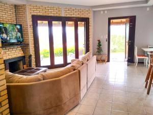 a living room with a couch and a fireplace at Morada Las Palmas in Praia do Rosa