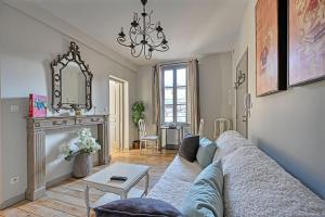 a living room with a couch and a fireplace at Au cœur des Papes, dans bâtisse de charme studios & appartements en cœur de ville in Avignon