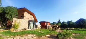 una casa en un campo con un árbol en Cabaña Ecologica, en Uspallata