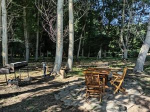 una mesa de madera y sillas en un parque con árboles en Cabaña Ecologica en Uspallata