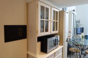 a kitchen with a cabinet with a tv and a table at Rue de France mer à 200m in Nice