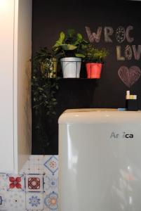 a white refrigerator in a room with potted plants at Art Marina nad rzeką z bezpłatnym parkingiem in Wrocław