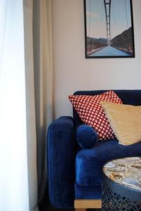 a blue couch with pillows and a table in a room at Art Marina nad rzeką z bezpłatnym parkingiem in Wrocław