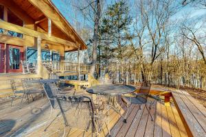 una terrazza in legno con tavolo e sedie su una cabina di War Eagle - Lake House a Rogers