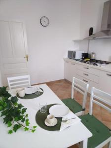 a kitchen with a white table with chairs and a white tableablish at Casa Sveva, a pochi passi dalle spiagge e dal centro di Arma di Taggia. in Arma di Taggia
