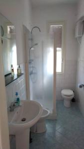a white bathroom with a sink and a toilet at Casa Sveva, a pochi passi dalle spiagge e dal centro di Arma di Taggia. in Arma di Taggia