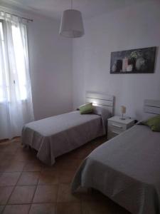a bedroom with two beds and a window at Casa Sveva, a pochi passi dalle spiagge e dal centro di Arma di Taggia. in Arma di Taggia +7 photos