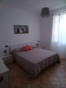 a bedroom with a bed with red pillows on it at Casa Sveva, a pochi passi dalle spiagge e dal centro di Arma di Taggia. in Arma di Taggia