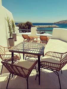 een patio met een tafel en stoelen op een dak bij All Blue Suites in Ambelas