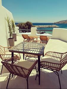 a patio with a table and chairs on a roof at All Blue Suites in Ambelas