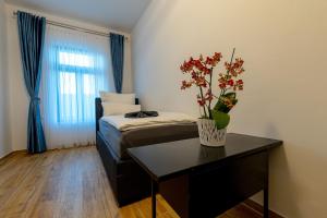 een kamer met een bed en een tafel met een vaas met bloemen bij 368 Plagwitz Apartment Kulturviertel in Leipzig