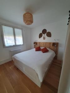 - une chambre avec un lit blanc et 2 oreillers rouges dans l'établissement Maison Zen proche circuit, au Mans