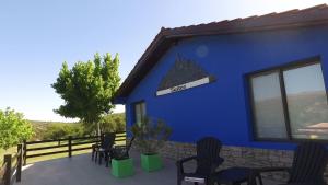 un edificio azul con sillas y un cartel en él en Los Ancares Resort en Mina Clavero