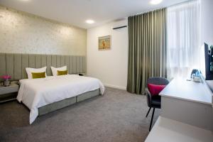 um quarto de hotel com uma cama e uma secretária em Benefice Hotel Yerevan em Yerevan