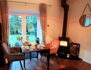 a living room with a table and a wood stove at Luxurious Riverside Cottage in Snowdonia National Park in Tanygrisiau
