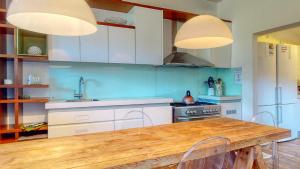 a kitchen with white cabinets and a wooden table at San Lameer Lux by Top Destinations Rentals in Southbroom