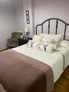 - une chambre dotée d'un grand lit avec des draps et des oreillers blancs dans l'établissement ALAMEDA 5, à Oviedo