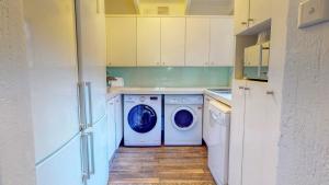 a kitchen with a washer and dryer in it at San Lameer Lux by Top Destinations Rentals in Southbroom