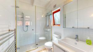 a bathroom with a shower and a sink and a toilet at San Lameer Lux by Top Destinations Rentals in Southbroom