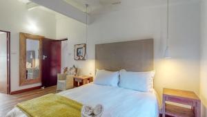 a bedroom with a large white bed and a mirror at San Lameer Lux by Top Destinations Rentals in Southbroom +33 photos