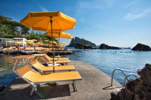 grupa stołów z parasolami na wodzie w obiekcie Gardenia Mare w mieście Ischia
