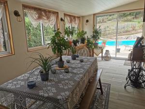 una sala da pranzo con tavolo e piante in vaso di DOMAINE DES 3 CYPRÈS Chambre MIMOSA Chez Nath & Pat a Fumel Altre 2 foto