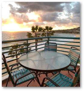 a table and chairs on a balcony overlooking the ocean at Laguna Surf in Laguna Beach