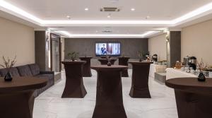 a salon with a lobby with tables and a tv at Premier Hotel Dnister in Lviv