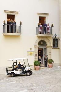 a man in a golf cart parked in front of a building at Hotel Palazzo Papaleo in Otranto