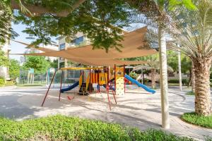 um parque infantil com um dossel e um escorrega em Vogue - The Greens and Views em Dubai