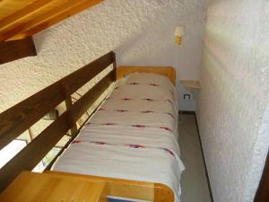 a small bed in a small room with a table at Appartement La Clusaz, 3 pièces, 8 personnes - FR-1-459-12 in La Clusaz