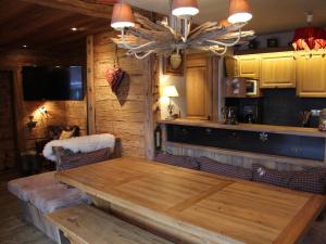 una sala da pranzo con tavolo in legno e una cucina di Appartement La Clusaz, 5 pièces, 9 personnes - FR-1-459-24 a La Clusaz