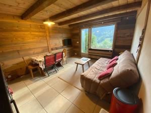 a living room of a log cabin with a couch and a table at Appartement La Clusaz, 3 pièces, 6 personnes - FR-1-459-28 in La Clusaz