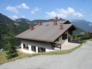 a house with a brown roof on a mountain at Appartement La Clusaz, 3 pièces, 6 personnes - FR-1-459-54 in La Clusaz