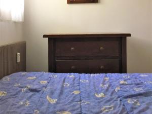 a bed with a blue comforter with a wooden head board at Appartement La Clusaz, 2 pièces, 4 personnes - FR-1-459-63 in La Clusaz